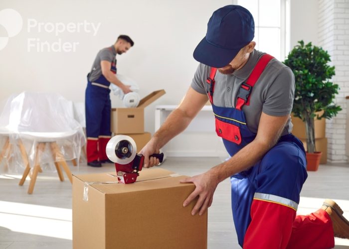 Young,Worker,In,Uniform,Holding,Packing,Duct,Tape,Gun,Roller